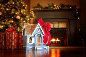 mini-house-with-red-bow-under-christmas-tree-with-fireplace